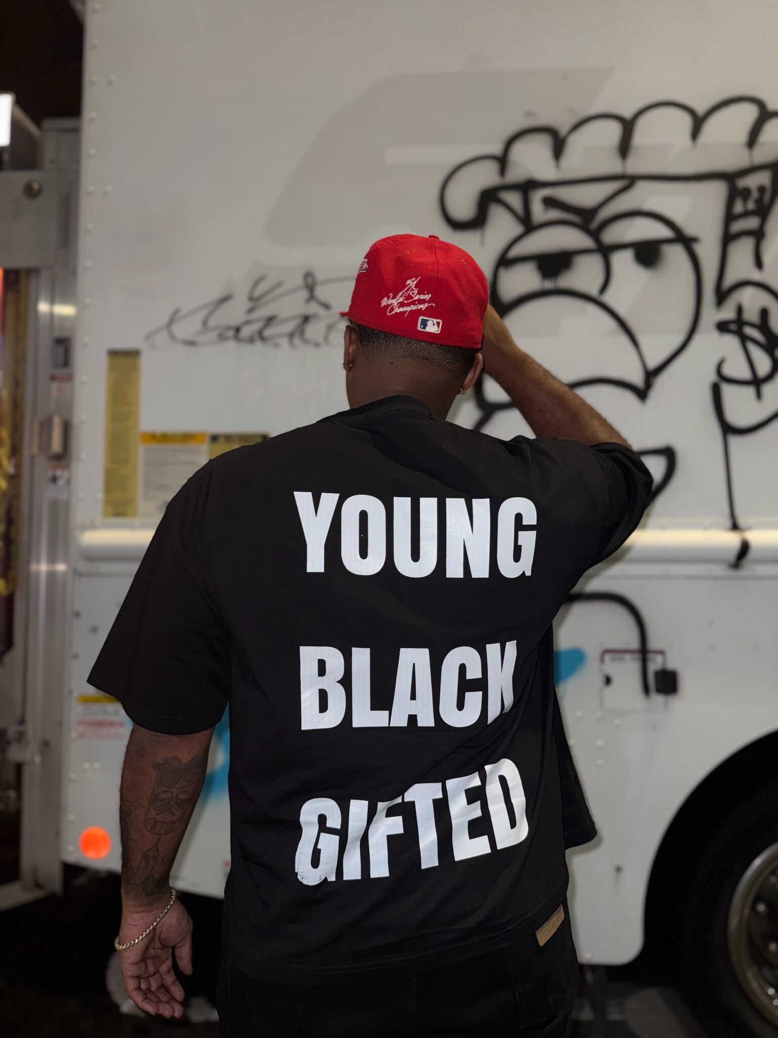 Christian Alexander wearing a Young Black Gifted shirt